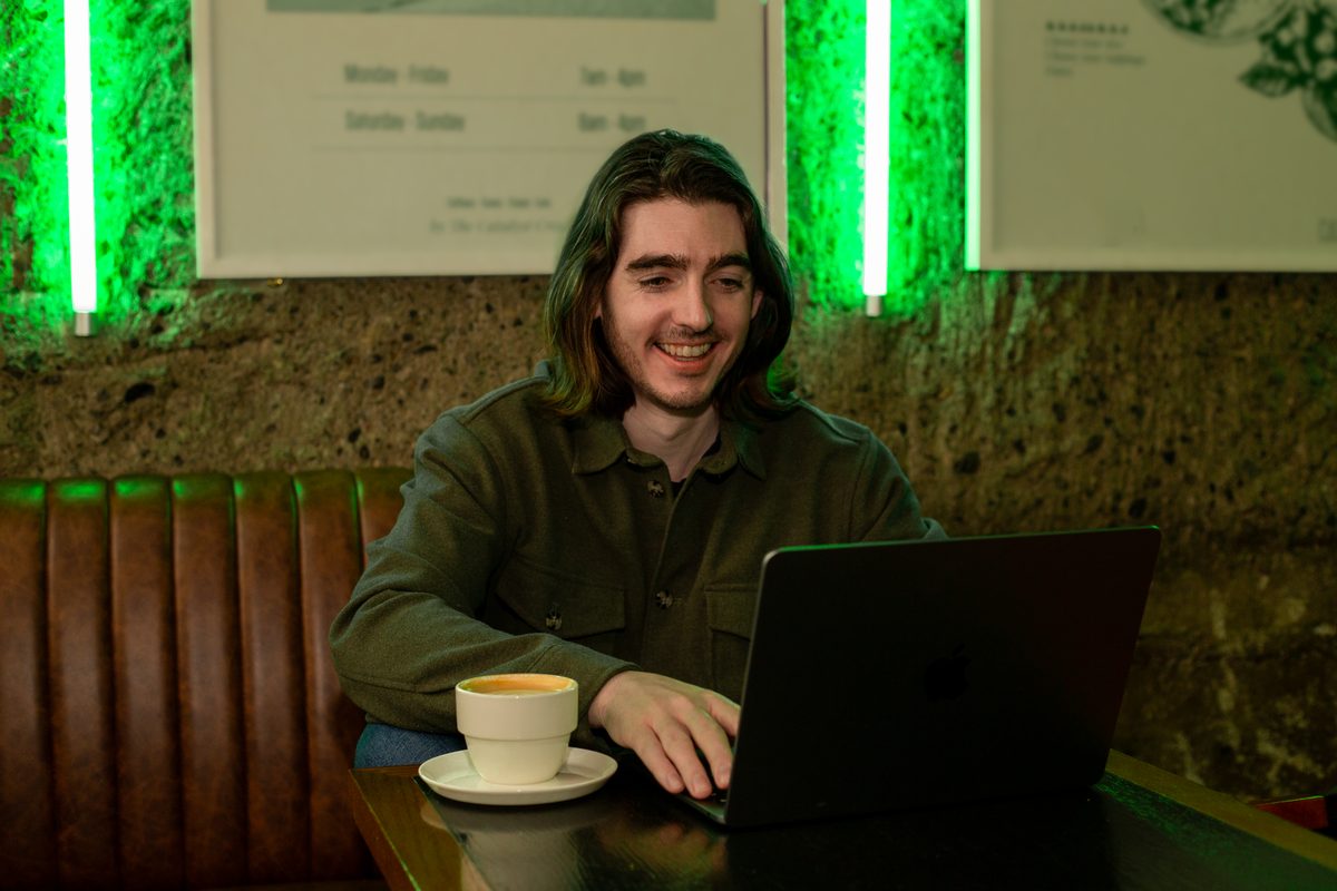 Ben Ó Mathúin smiling while working at his laptop